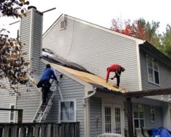 Workers on roof of house