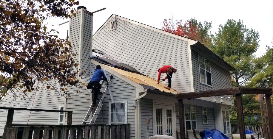 Two workers on roof of house