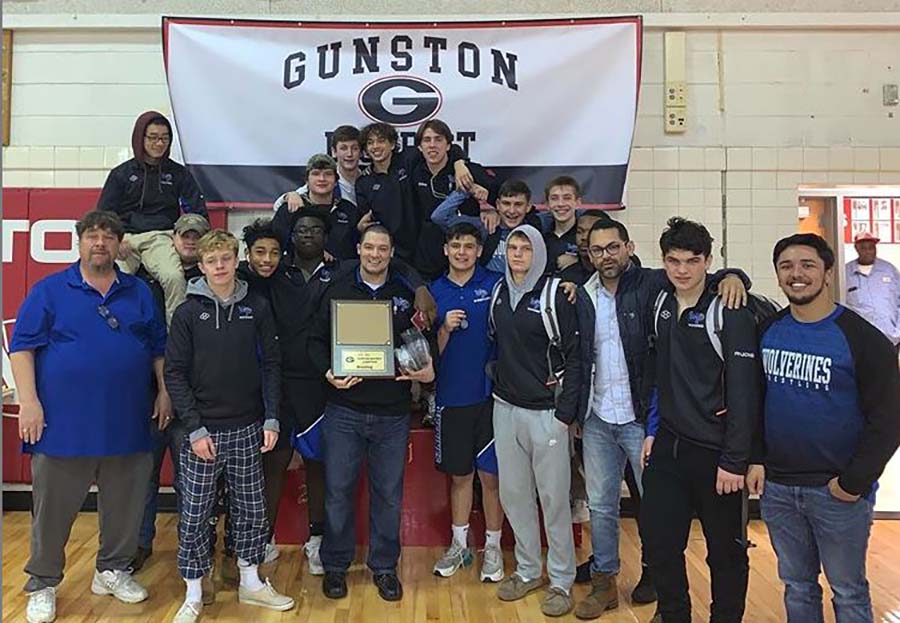 Coaches and team together in front of Gunston District banner