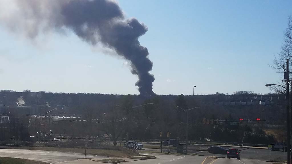 Thick chimney of smoke rising into the sky