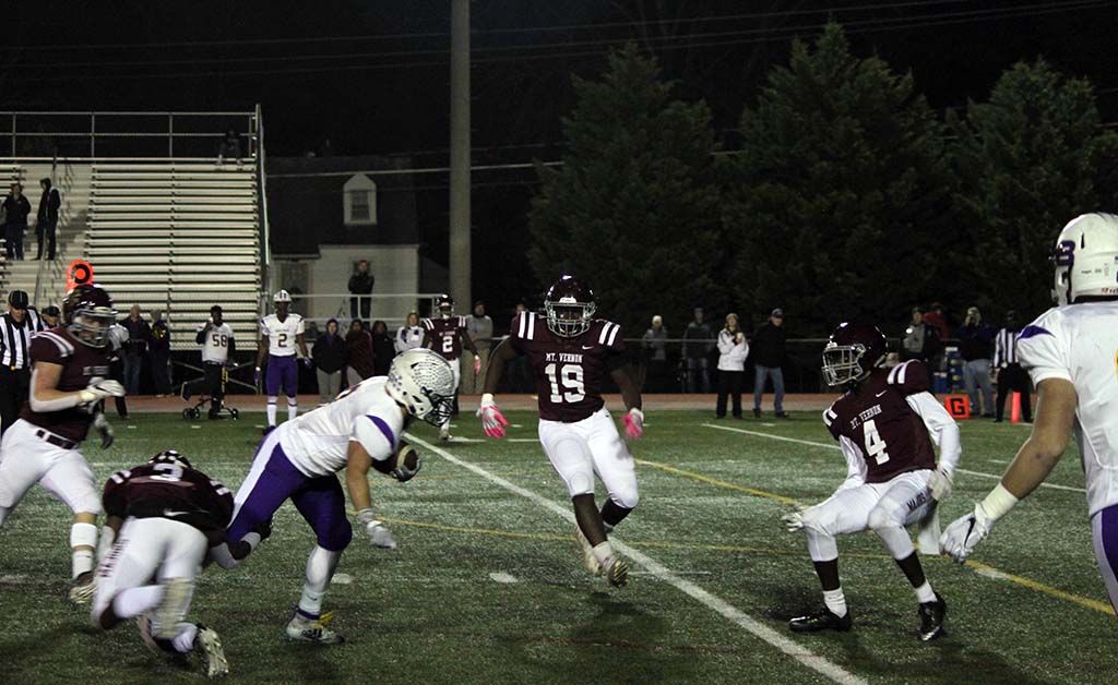 Lake Braddock player running just as he's hit by one defender with two others closing in