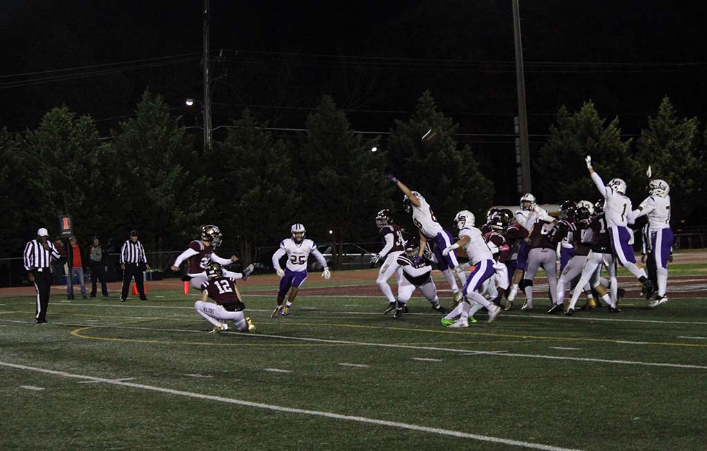 Kicking an extra point over outstretched arms of Lake Braddock defenders