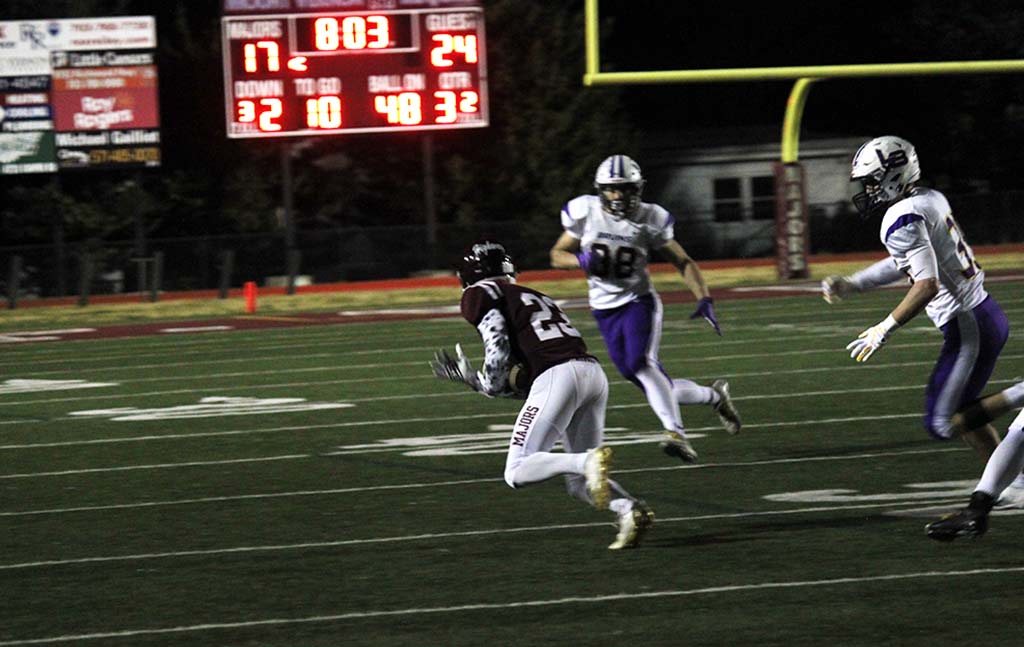 Danso being pursued by two Lake Braddock players with scoreboard in background