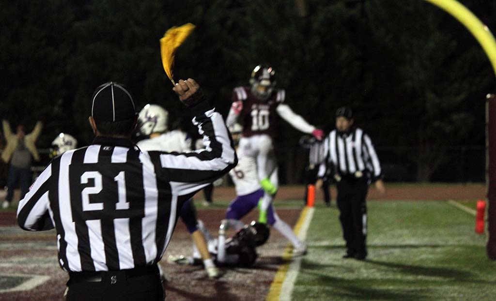 Referee wearing #21 throws a flag