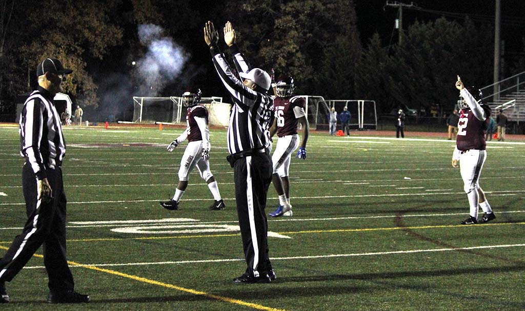 Referee giving the touchdown signal, smoke from cannon in background