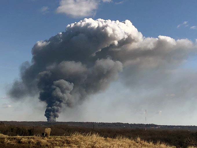 Thick smoke, black and the bottom and white at the top, rising from the fire