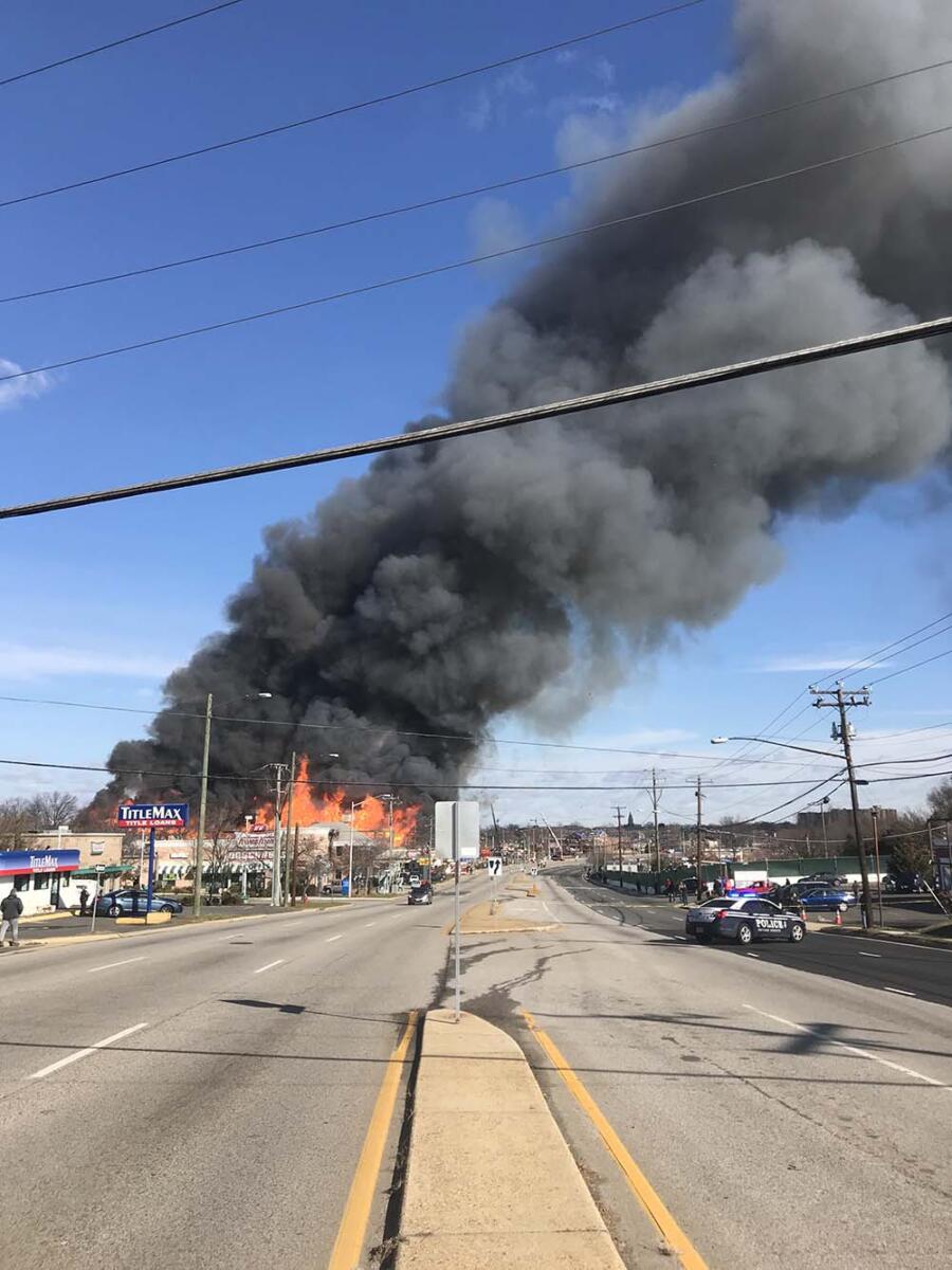 Thick black smoke rising above flames, seen from a high point