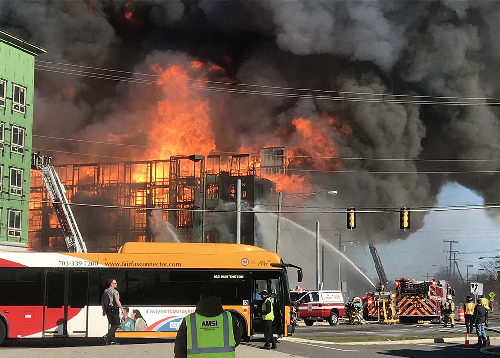 Bright orange flames burning, with a Fairfax Connector bus in the foreground