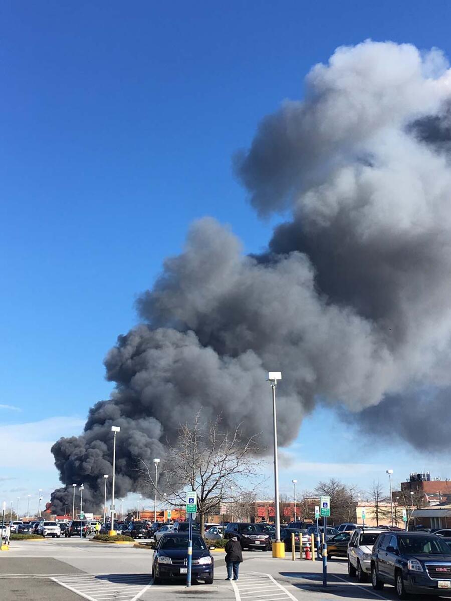 Black smoke seen in blue sky from a distance