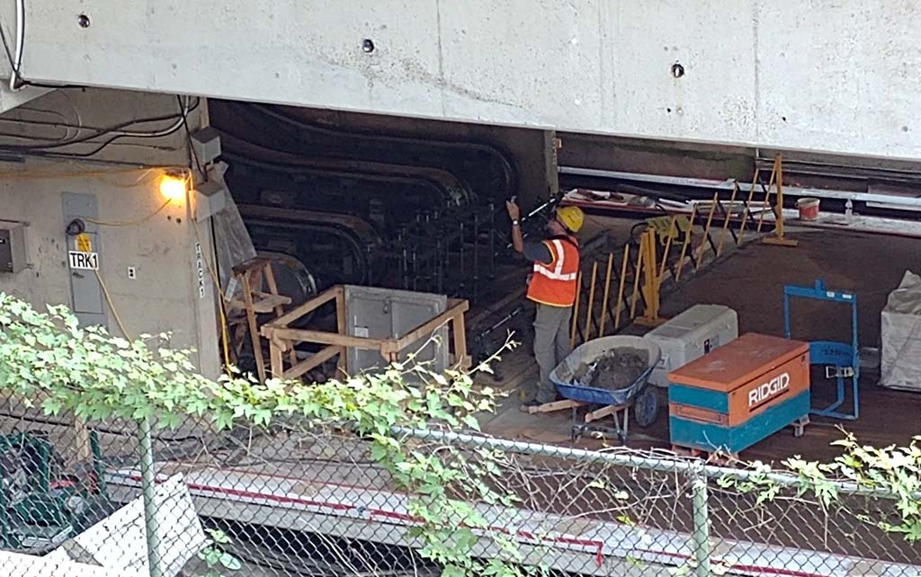 View of worker on platform near escalators